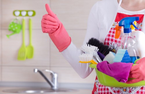 Experienced cleaner dusting furniture in a Camden home